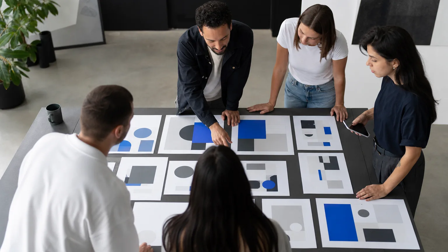Equipe organizando sobre a mesa as seções impressas de uma landing page